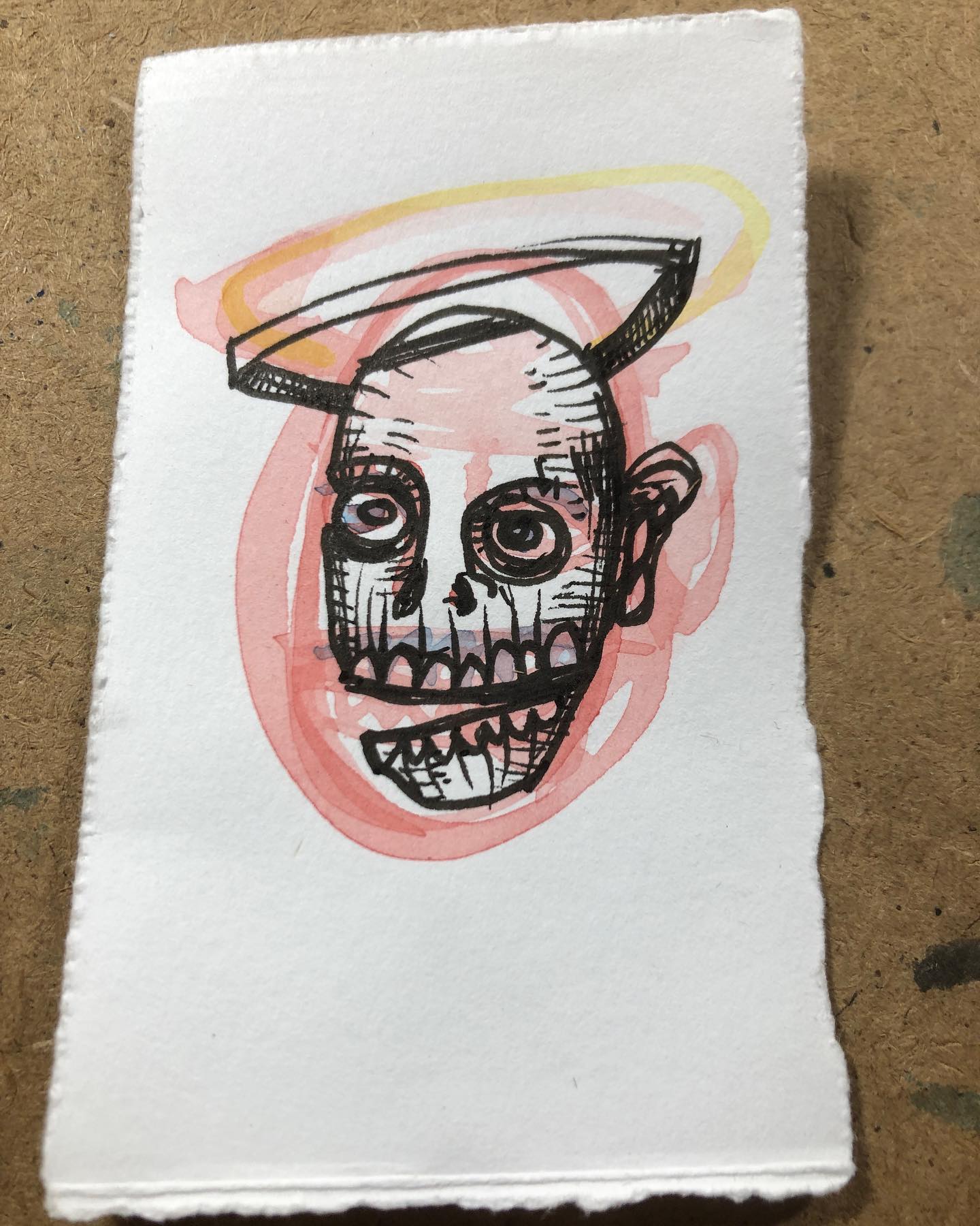 Ink and watercolor drawing of a skull with halo