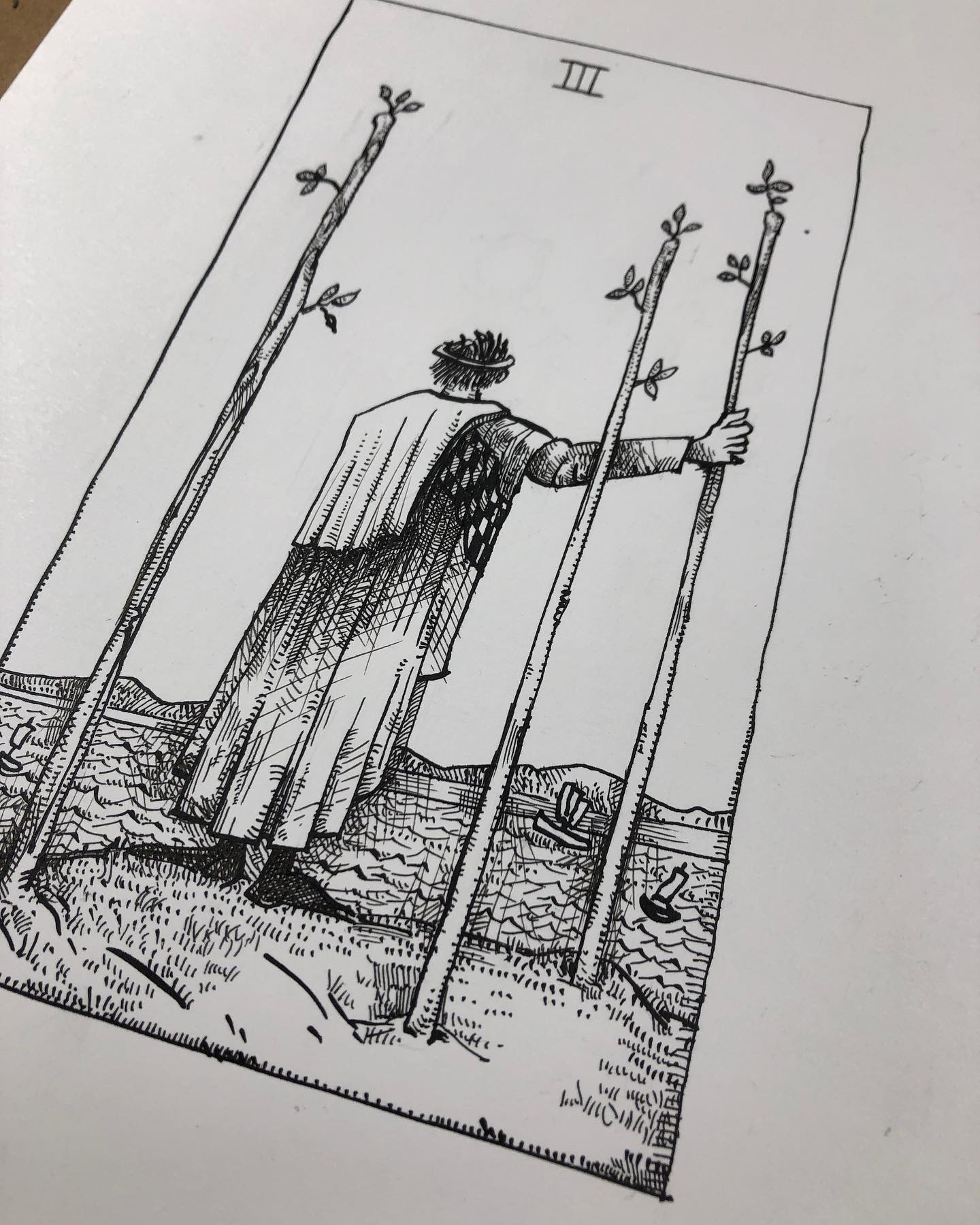 Tarot drawing - Three of Wands card - man holding one of three staffs overlooking a large body of water